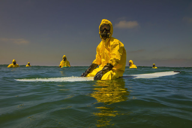 Activist Surfs In Hazmat Suit To Depict The Possible Future Of Oceans